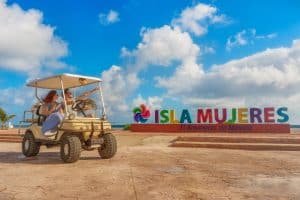 golf cart in front of isla mujeres sign
