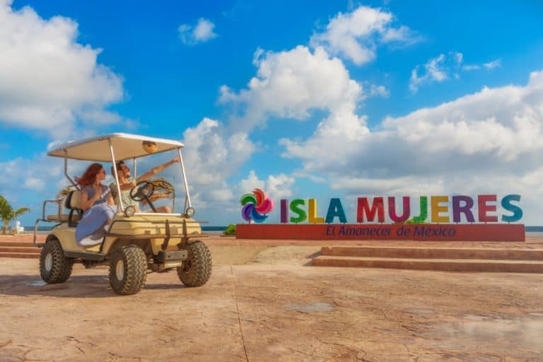 golf cart in front of isla mujeres sign