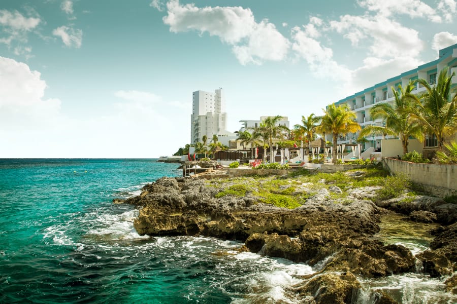 rugged coastline of cozumel with hotel in background