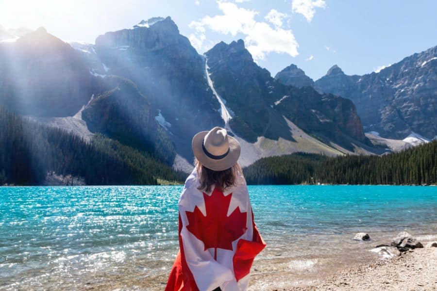 Person With A Canadian Flag Standing Near Lake in Alberta sp