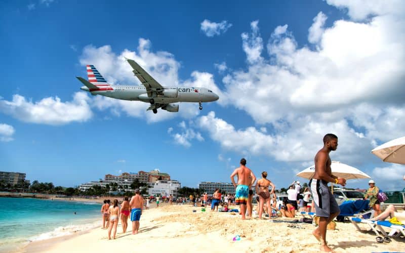 Many Tourists observe low flying airplanes landing near Maho Beach Caribbean