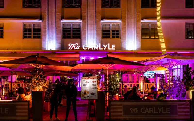 Art deco famous district at night with neon pink light sign of the Carlyle restaurant