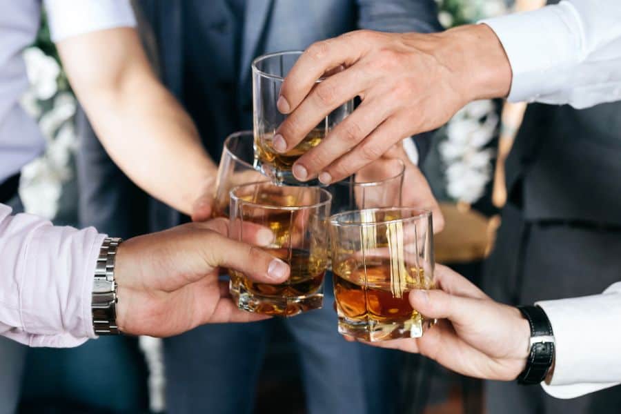 Group of friends guys with glasses of whiskey