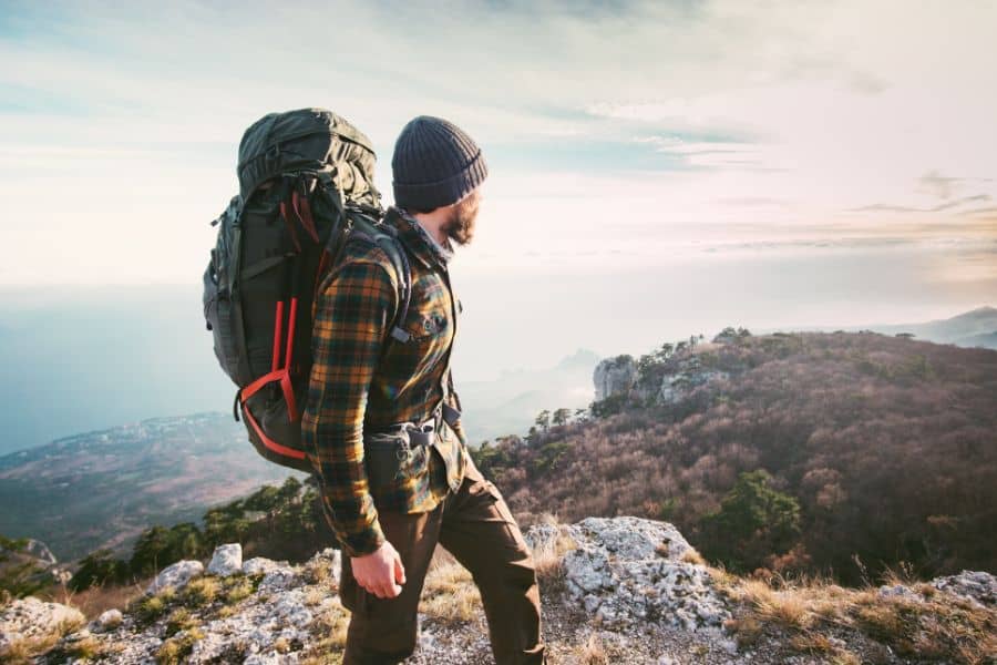 Man traveling with backpack hiking in mountains