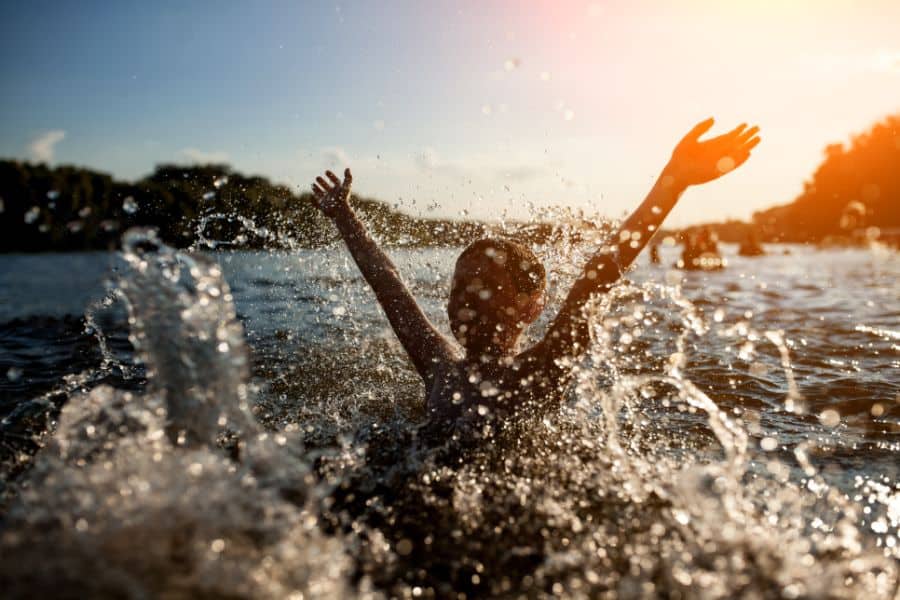 Little kid play in water and making splash