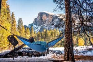 Man in a hammock enjoying the picturesque winter landscape of Half dome Yosemite national park