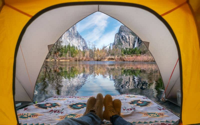 travellers feet in tent with yosemite national park view
