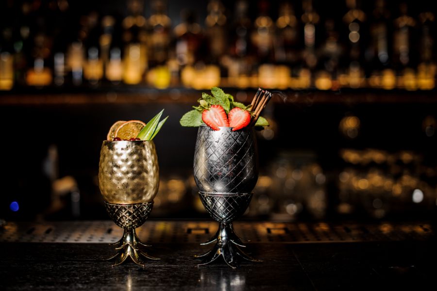 Two cocktails in a dimly lit bar