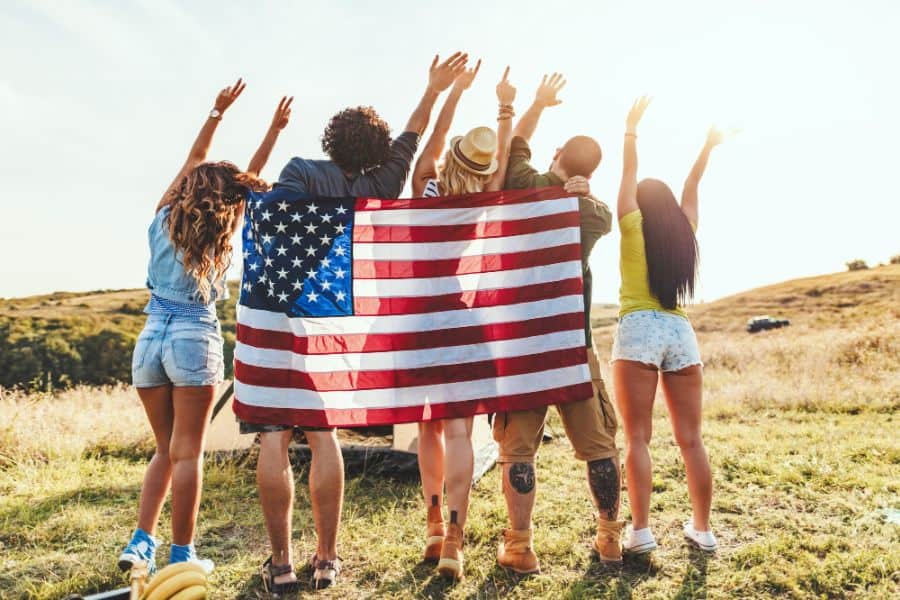 group of young friends posing the with usa flag