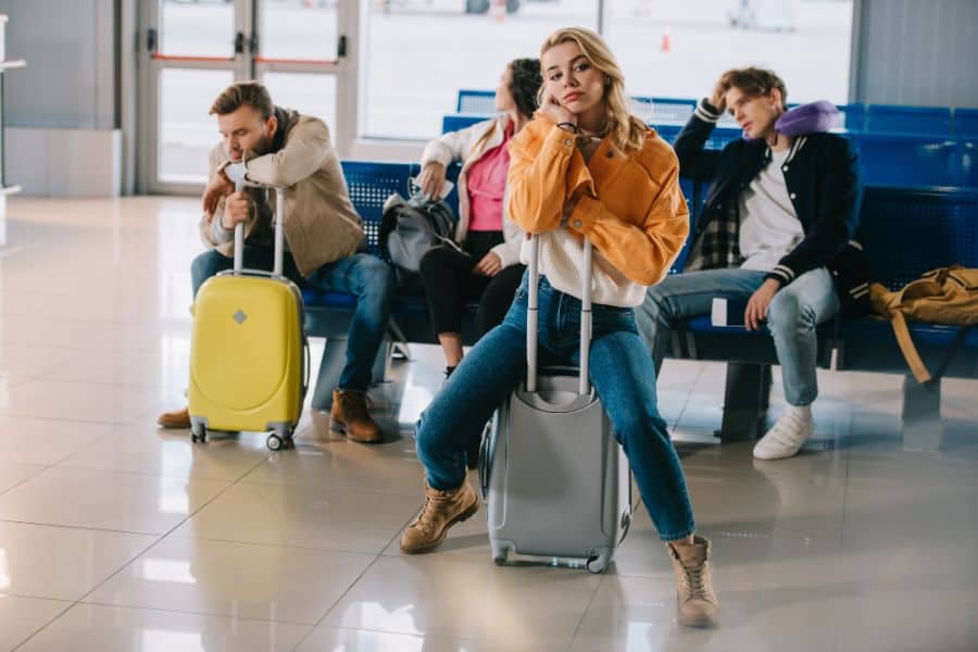 Bored young people with luggage waiting for flight