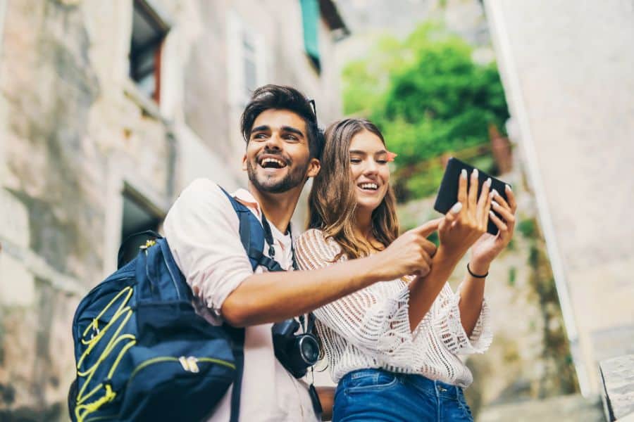 happy couple traveling and using tablet