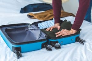 person packing carry on luggage