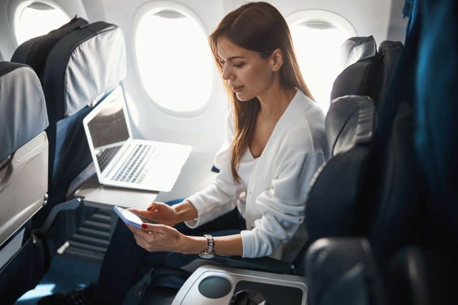 young lady with two modern gadgets in the plane