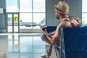 Traveler waiting at airport with passports and tickets