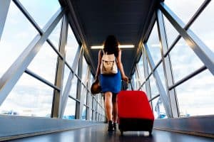 Young girl traveler walking to board plane with carry on suitcase