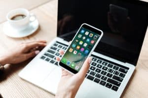 cropped view of woman holding iphone in office