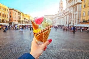 gelato held in hand on the background of Piazza Navona rome