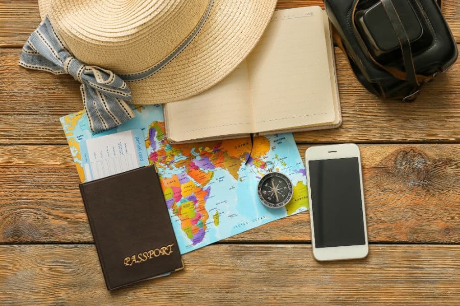 world map compass and passport on wooden background