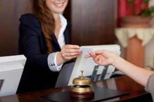 Female receptionist passing hotel key card