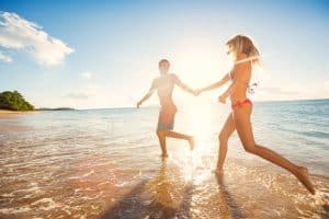 Happy Couple on Tropical Beach at Sunset