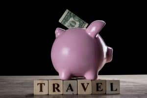 Piggy bank and letter cubes forming the word travel