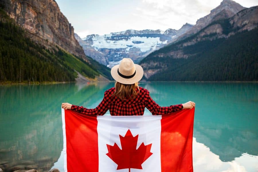 Woman Wearing Red and Black Checkered Dress Shirt holding canada flag sp