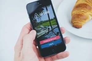 hand holding an iphone with airbnb app open sp