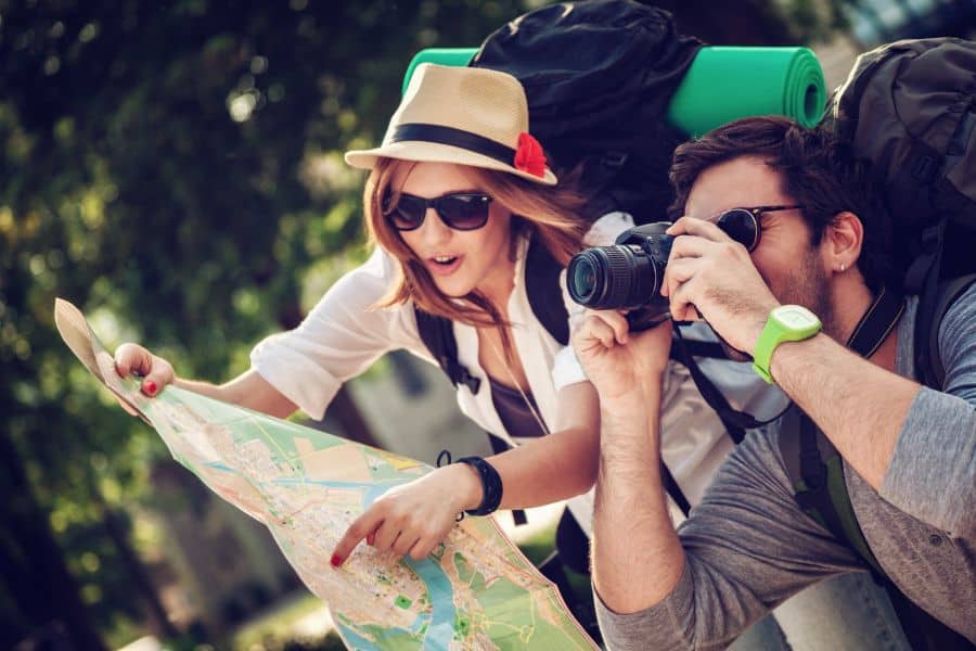 man and woman tourist with map and camera