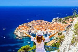 young girl enjoys view of old town (medieval Ragusa) and Dalmatian Coast of Adriatic Sea in Dubrovnik croatia