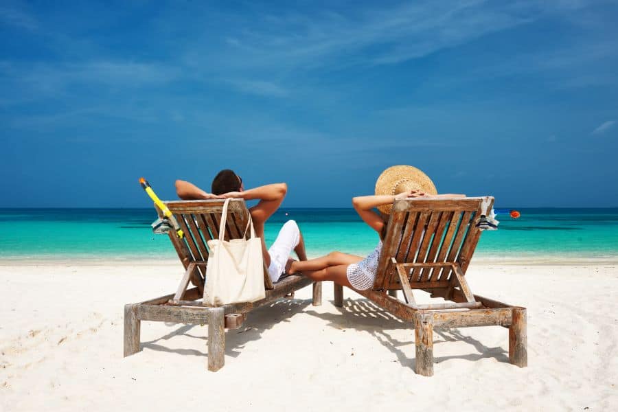 Couple in white relax on a beach at Maldives