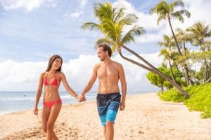 Hawaii beach vacation couple walking happy on Kaanapali beach Maui Hawaii USA