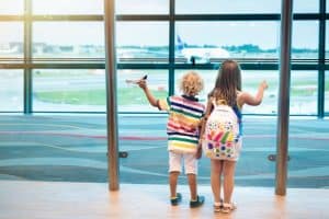 Kids at airport looking at an airplane