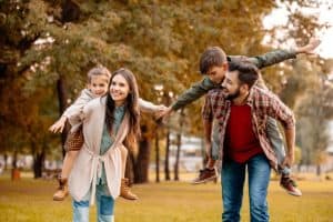 Parents giving children piggyback ride during autumn