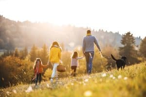 family with two small children and a dog on a walk in autumn nature