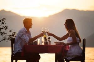 Young couple sharing romantic sunset dinner on the beach