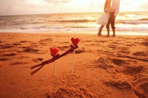 newlywed embracing on beach during sunset