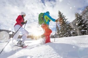 snowshoe walkers running in powder snow with beautiful sunrise