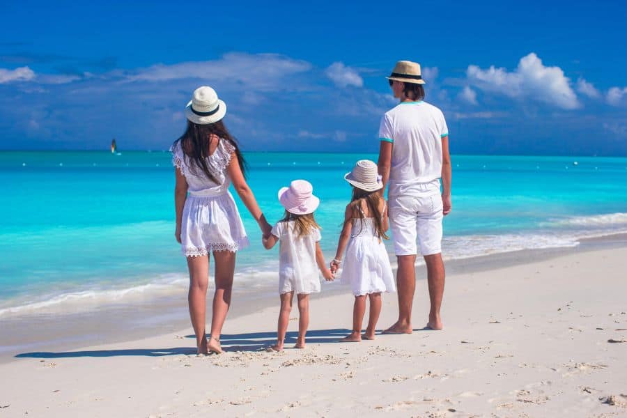 Back view of young family with two kids on caribbean vacation