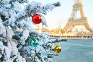 Christmas tree covered with snow eiffel tower in the background