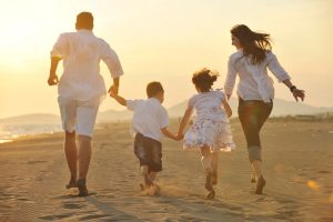 Happy young family have fun on beach at sunset