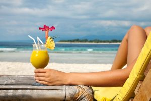 woman Holding a cocktail on a tropical beach