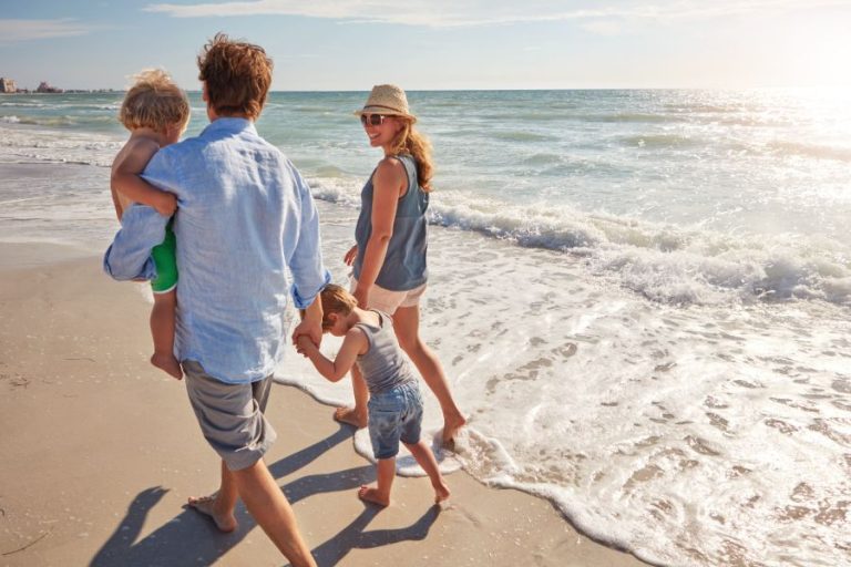 Taking a walk on the beach a young family enjoying a summer day out at the beach