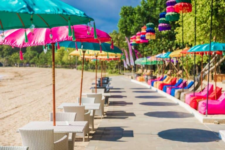 Cafe with colorful balinese umbrellas at tropical beach in Bali Nusa Dua