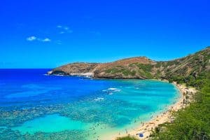 Tourists playing in the water at a beach in Oahu