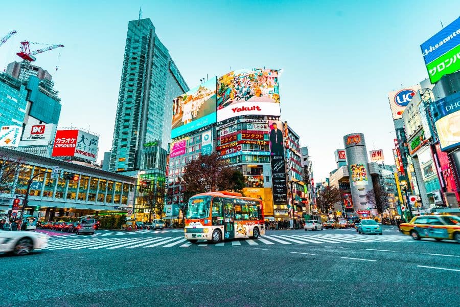 white and red bus in the middle of crossing street tokyo japan sp
