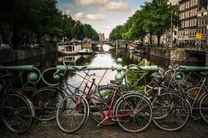 bicycles beside blue rails near canal amsterdam sp